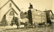 Man atop trailer of wood being pulled by two horses, Labor Day, Harbor Spri