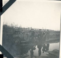 Allen and other people beside an automobiles stuck in the mud