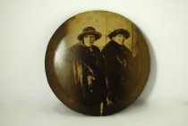 Large button with two women on it.
