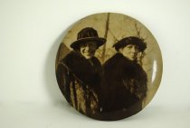 Large button with two women on it.
