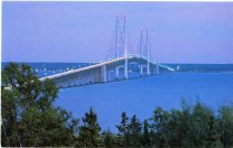 The Mackinac Bridge at dusk or dawn with its lights on.