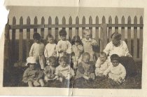 Baby room children and Volunteer next to fence