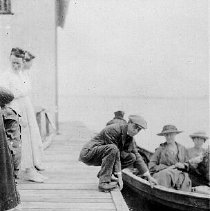 People in a row boat at a dock, photograph, ca. 1915.