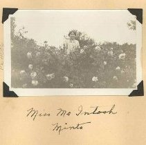 Miss McIntosh of Minto standing in flower garden, ca. 1930