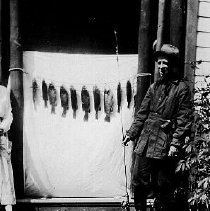 Man with fishing rod and stringer of fish, photograph, 1920.