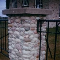 240 stone pillar at front of church