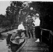Fishermen and woman on a dock, photograph, ca. 1915.