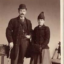 Man with walking stick and woman with muff related to Wilson and McQueen families of Fergus, ca. 1890