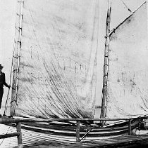 Person standing on a docked sailboat, photograph, ca. 1915.