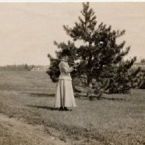 ph 16113: Woman, with gun on shoulder, next to tree [Kingsmill / Cruickston