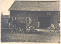 Ike Sabean driving lumber carrier by Maloney's Livery Stable in North Bend