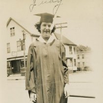 Judy in cap and gown, in front of Margaret's Beauty Shop