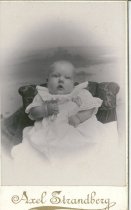 Infant propped on cushion