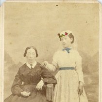 Older lady in dark colored dress and young girl standing