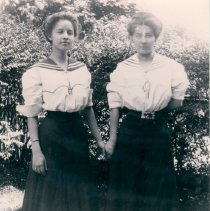 Two women hold hands.
