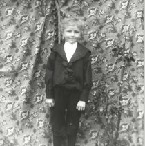 Boy in front of drape