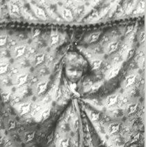 Boy peeking through drape