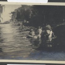 Three people swimming