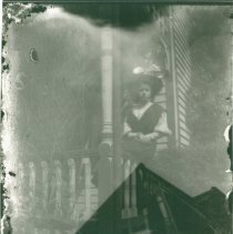 Alma Morse Partridge sitting on porch railing