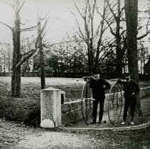 S999.211 Two Men Next To Penny Farthings