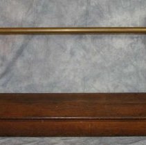 A wooden kneeling bench with brass handle.