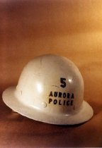 White Aurora Police hard hat against a sepia backdrop.