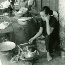 Woman cooking over open fire