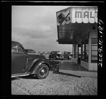 Automobiles parked by malt shop, c. 1942