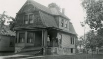 Unknown family standing on the porch of house on Ogden St