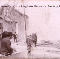 People observing the remains of what appears to be a church fire.