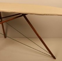 Wooden ironing board with white cloth cover; c.1940.