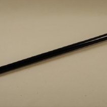 Wooden, black enameled walking stick with gold-colored knob; unknown date.
