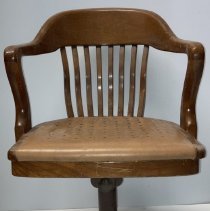 Wooden chair with light brown seat and dark brown painted cylindrical base.
