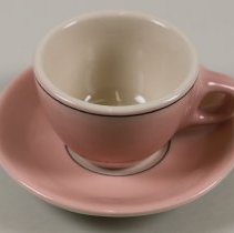 Teacup and saucer with pink and white glazing; unknown date.