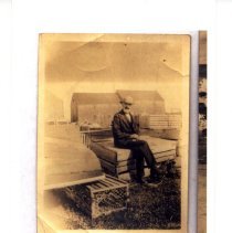 Man sitting near boat & lobster traps