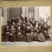 group of women sitting on steps of wood church