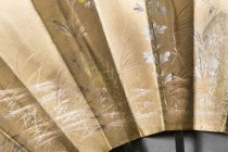 detail of front, frog holding yellow flower