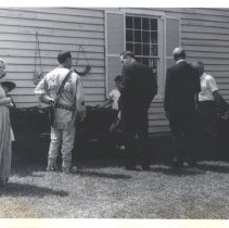 Opening of Bradley House, Curator outside with display of guns