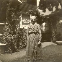 Elderly woman in front of home