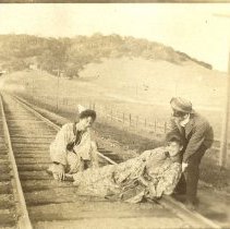 Three on railroad tracks
