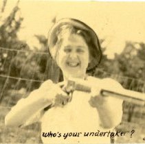 "Whos your undertaker?" Unknown smiling lady with rifle aimed. 1909