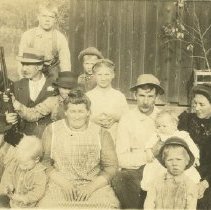 "Early prohibition?" no date. Large family in front of barn with 2 rifles