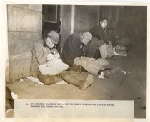 Two elderly Japanese men spend the night outside the train station.
