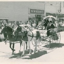 Two men seated on a horse-drawn carriage (1952)