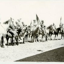 Black and white print of several men and women on horseback; flags visible