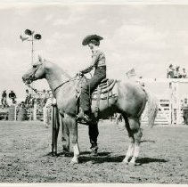 Profile of a Joan Schoemaker on horseback next to a microphone