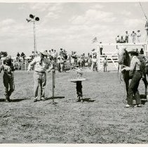 Joan Shoemarker tying her horse; Petey Stark at the microphone