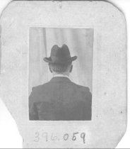 Man facing backwards in the same suit, vest, tie and derby hat.  (See 396.058)