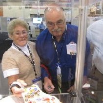 Past APCO President Gary Gray preparing to add a pin to Lin Ford's vest.