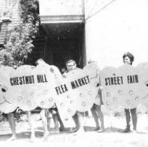 29.Holding giant imitation "fleas" that promoted a flea market